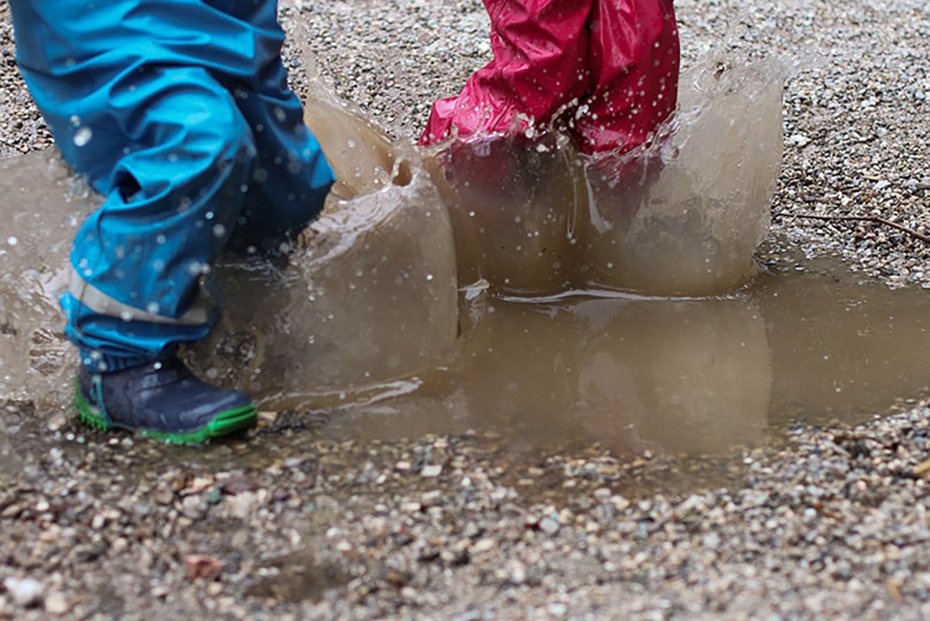 Kinder springen in Pfütze